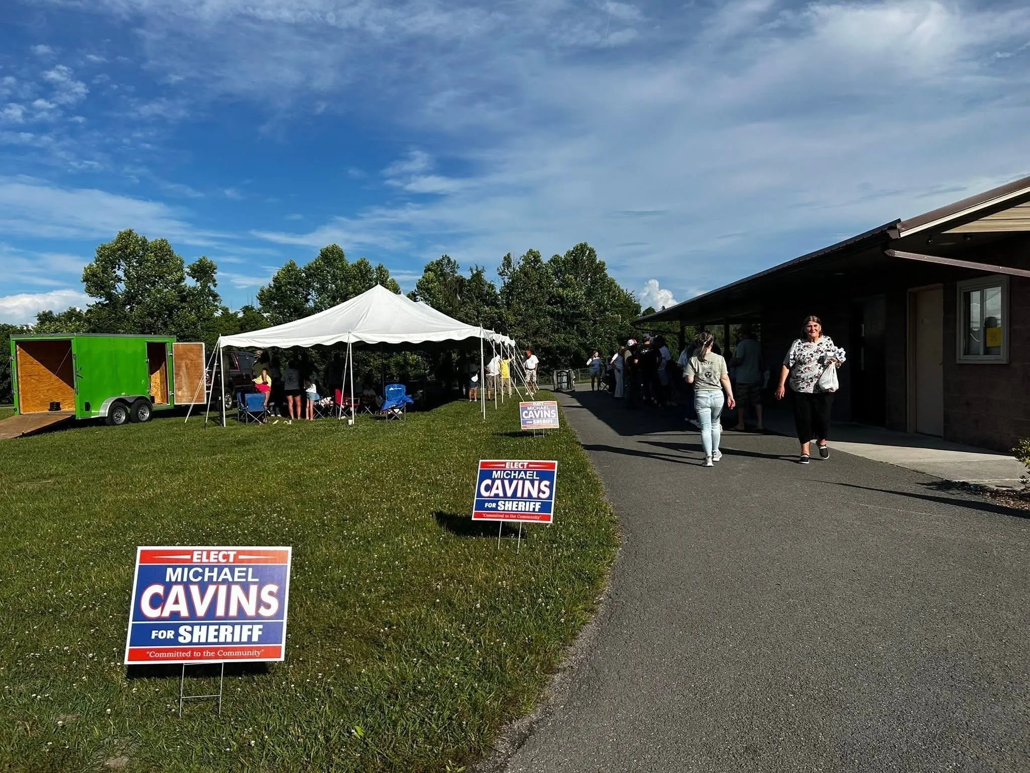 Supporters gathered under a tent at a Cavins for Sheriff meet and greet with yard signs along the drive