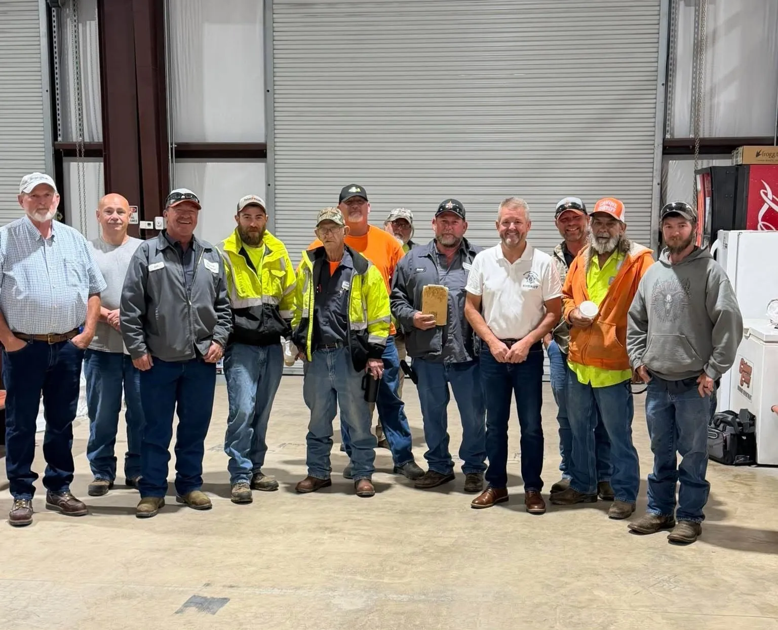 Michael Cavins with members of the Claiborne County road department in their equipment garage