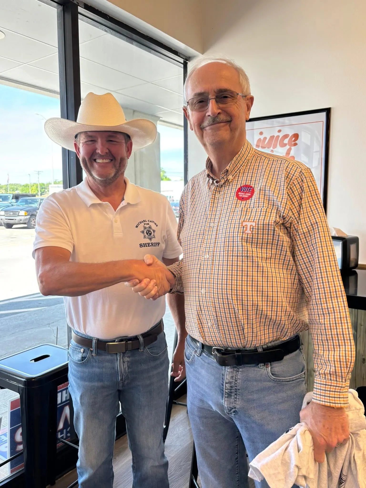 Michael Cavins shaking hands with a supporter wearing a Cavins for Sheriff sticker